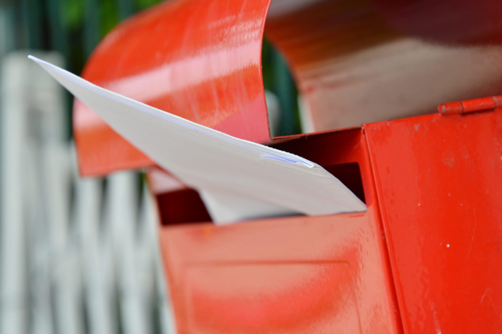 letter in red mail box on home fence